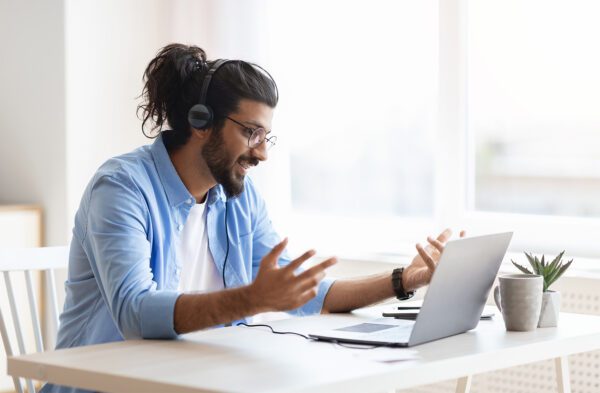 A man wearing headphones and using a laptop.